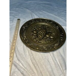 Brass round plate with ornate embossed fruit design decorative metalware